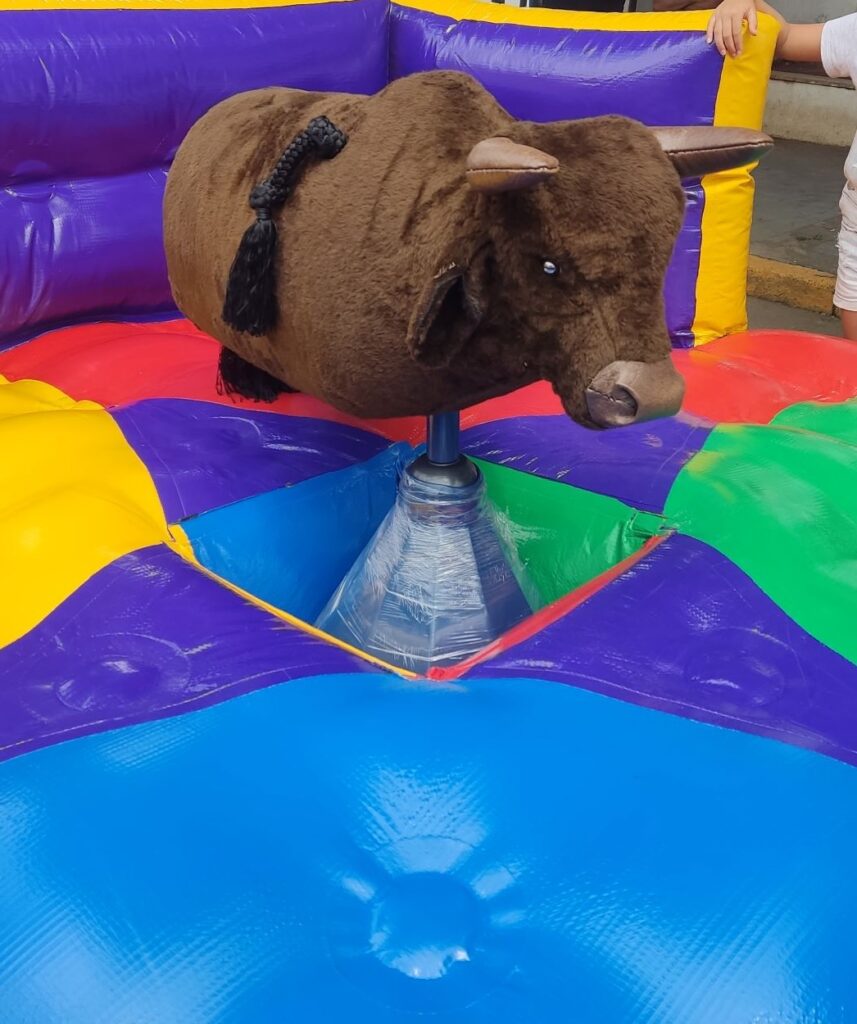 Baby Bull, o touro mecânico infantil da Castelinho Kids, sobre a base inflável colorida