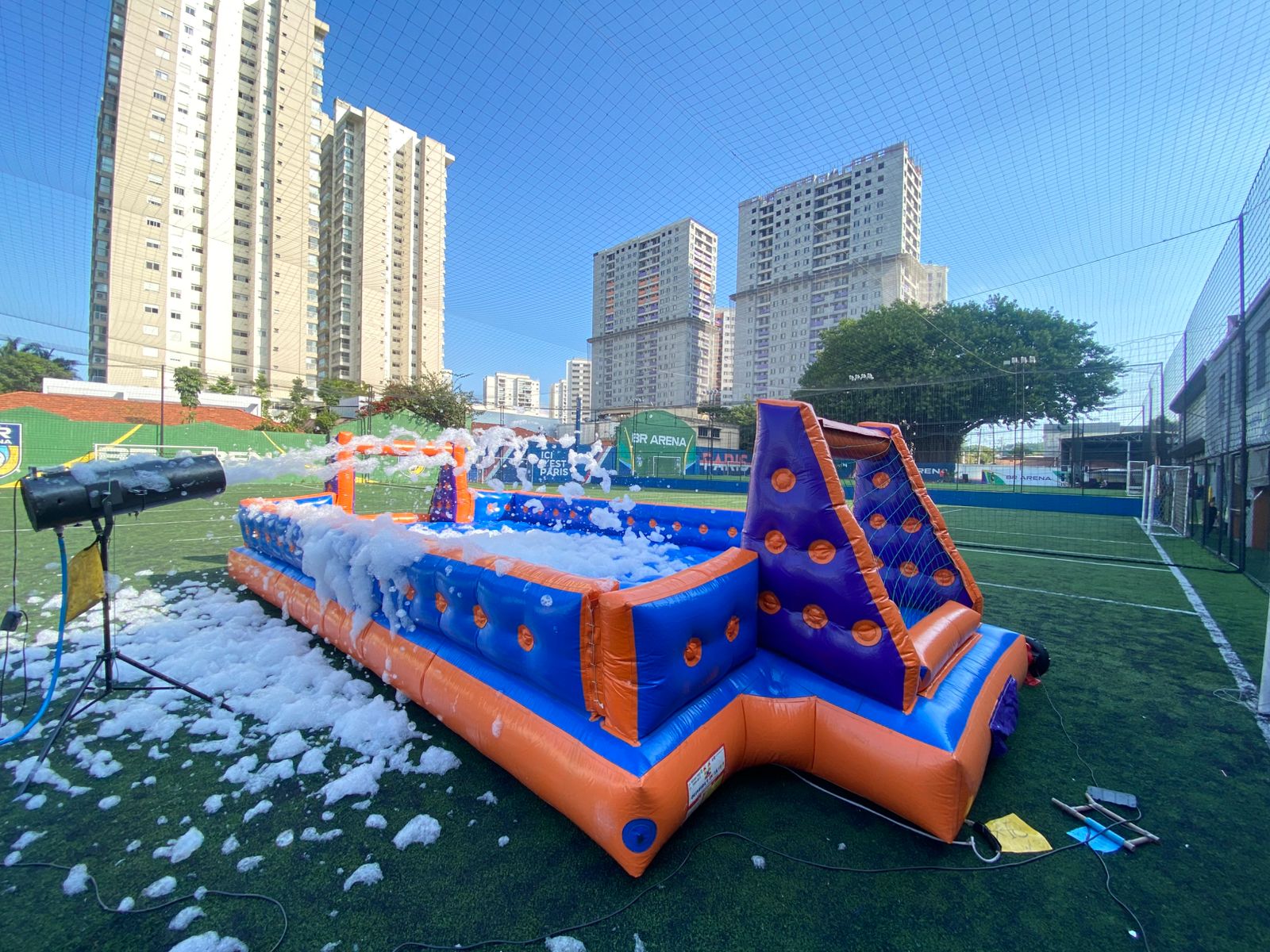 Arena inflável de futebol de sabão com o canhão de espuma jogando espuma sobre o campo, montada em quadra