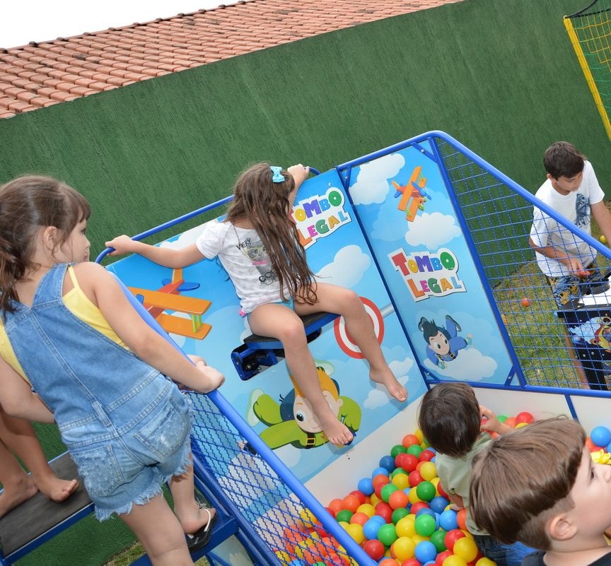 Crianças brincando no brinquedo montado durante uma festa infantil, com a piscina de bolinhas em primeiro plano